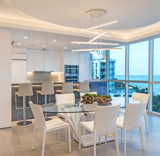 a modern dining room with a table and chairs with an ocean view