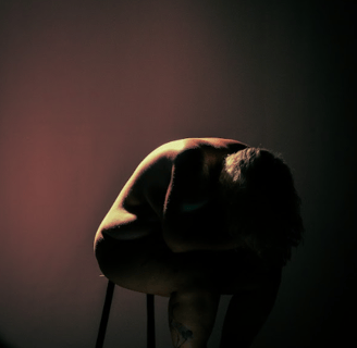 a man sitting on a chair in a dark room