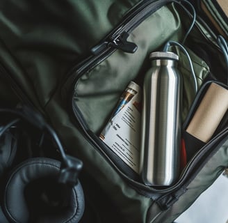 An open dark green travel bag contains a stainless steel water bottle.