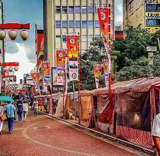 Rua Liberdade em São Paulo, com lanternas japonesas, bandeiras e uma feirinha.