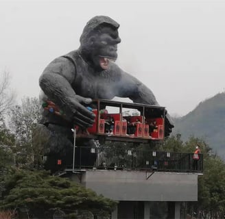a giant gorilla statue of a gorilla sitting amusement equipment on top of a building