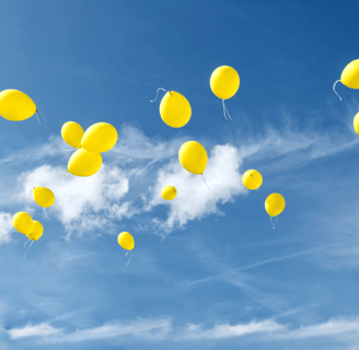 Cielo azzurro limpido con palloncini gialli che volano via, simbolo del lasciare andare, di libertà