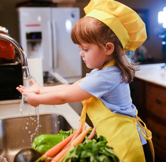 Little girl washing hands in kitchen sink