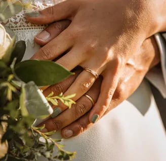 a bride and groom holding hands in front of a bouquet