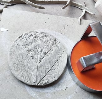 a person using a circular tile cutter to make a clay tile printed with thing from natures