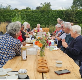 a group of people sitting at a table with coffee and tea at chiswick house