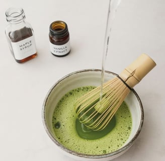 Whisking matcha with hot water, maple syrup and vanilla