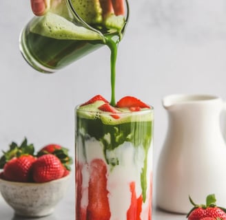 Green matcha poured over milk and strawberry layers