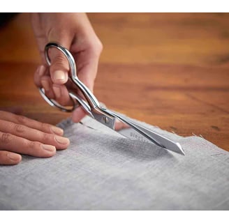 a person holding a pair of scissors and a pair of scissors