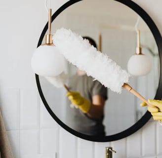 a person cleaning a mirror in a bathroom