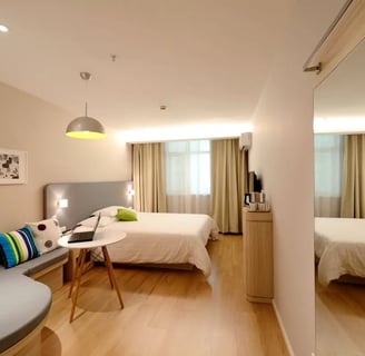 a clean bedroom with a couch and a bed in the background