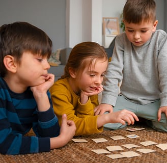 Crianças jogando um jogo de memória com cartas no chão