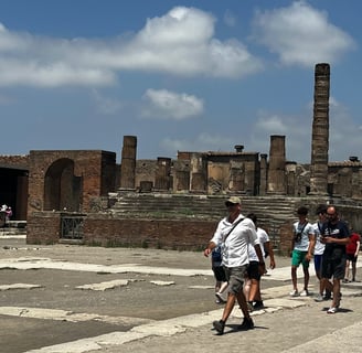 grupo de turistas andando pelos restos da cidade de Pompeia