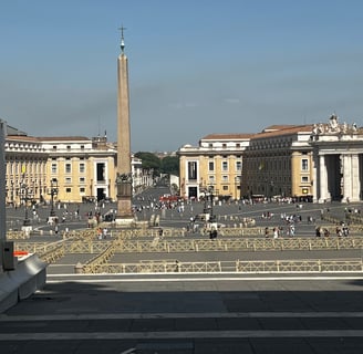 pessoas caminhando em praça com obelisco no centro