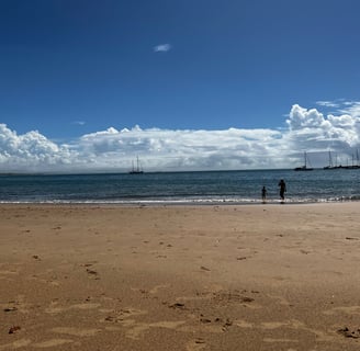 céu com nuvens sob mar com barcos ao fundo
