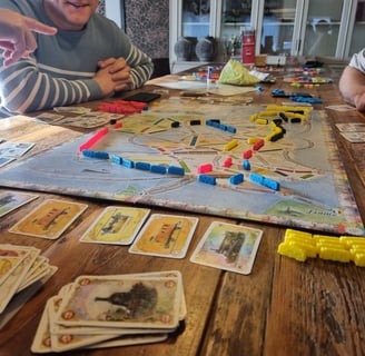 Een tafel met het bordspel Ticket to Ride