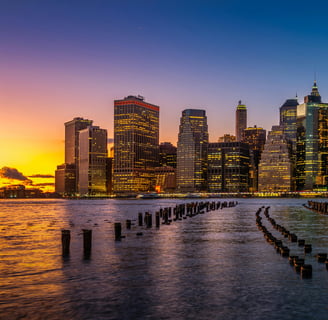 a city skyline with a sunset over the water
