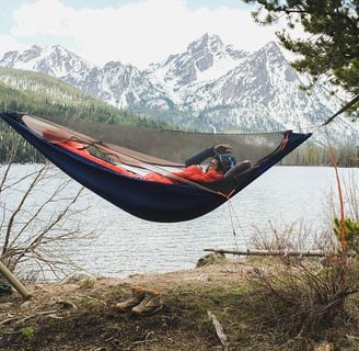 a man in a hammock with a backpack on a hammock