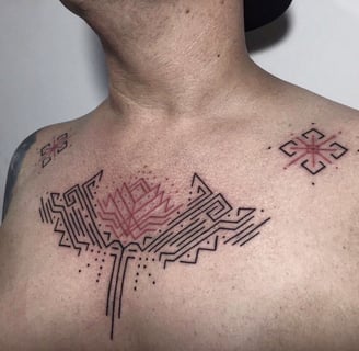 An handpoked tattoo featuring geomatric ornaments tappis pattrens inspired, tattoo on chest