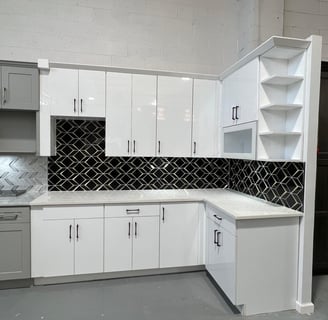 a kitchen with white cabinets and black and white cabinets