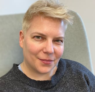 Portrait of a woman with short bleached hair and a blue sweater