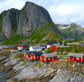 a mountain range with a red house and a mountain in the background