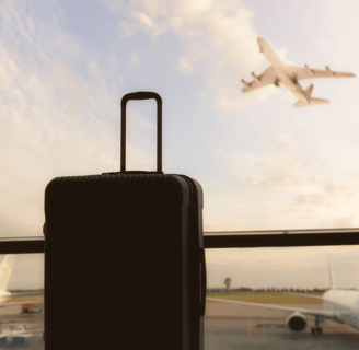 a suitcase and a suitcase in front of a window