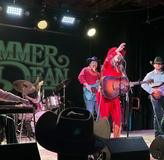 Country musician SUmmer Dean playing her acoustic guitar on stage