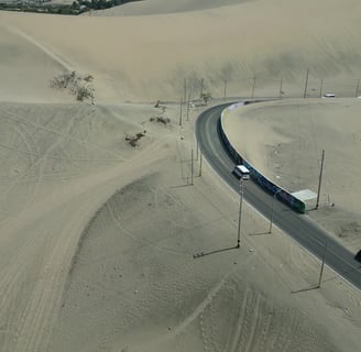 Aerial Drone Shot of a vehicle passing through the desert of Huacachina Oasis Peru