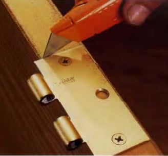 a person using a knife to cut a piece of wood