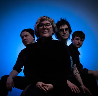 a group of people standing around a man with a tattoo on his arm