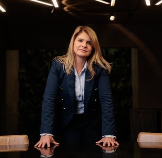 a woman in a suit and tie is standing in front of a table