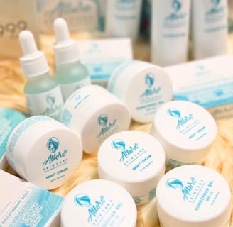 Various Allors Skin Care products, including night creams, serums, and soaps, displayed on a soft surface with a blue