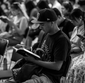 a man sitting in a chair with a bible in his lap
