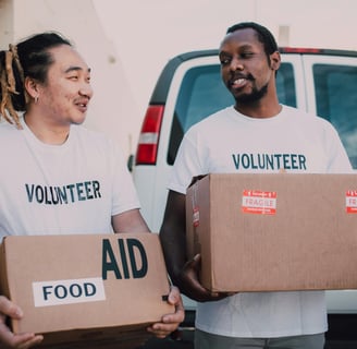 two men in white shirts are holding boxes with boxes