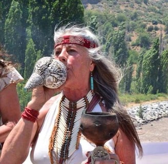 Mujer tocando un cuerno ceremonial