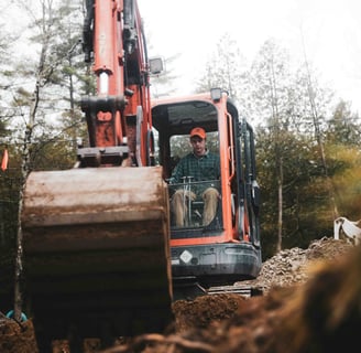 worker in an excavator digs a hole