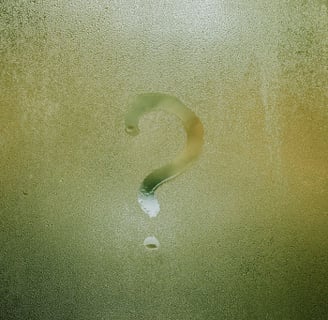 Question mark drawn on a rainy window questioning what is the deal with meditation.