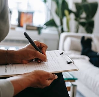 a person holding a pen and writing on a notebook