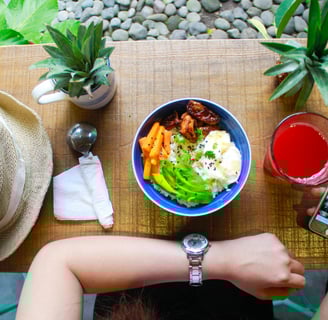 a person sitting at a table with a bowl of food. A quick boost for her mental health due to this.