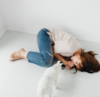 a woman sleeping on the floor while a dog stares at her (instantly relieving her mental health)