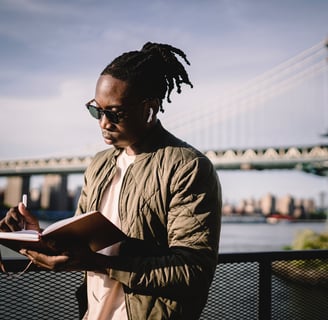 a man journaling outside while listening to music knowing it'll relieve his mental health swiftly