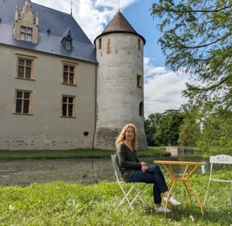 Aujourd'hui, Arielle, fille de Marie-Sol de La Tour d'Auvergne, assise en face  du château