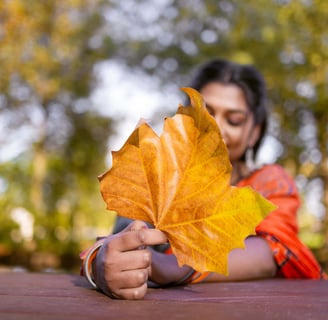 a woman holding a leaflet in front of a tree