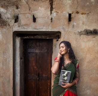 a woman in a saree posing infront of the wall