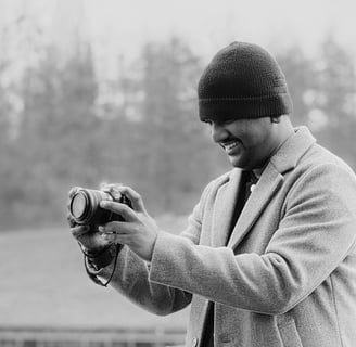 a man in a coat and hat is holding a camera