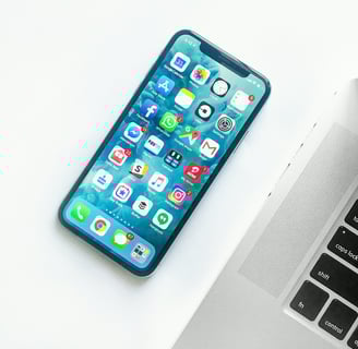 a cell phone and a laptop on a desk