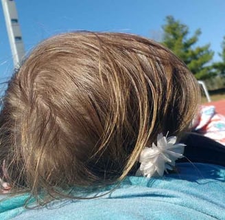 a woman and child laying on a blanket in the grass