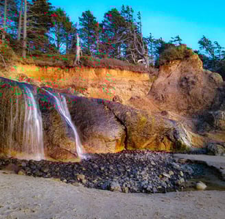 Oregon Coast - The waterfall coming down the cliffs at Hug Point State Rec site on the beach