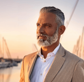 Well dressed man standing port side at golden hour